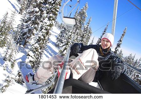 Stock Image - Girl in ski lift on ski hill. Fotosearch