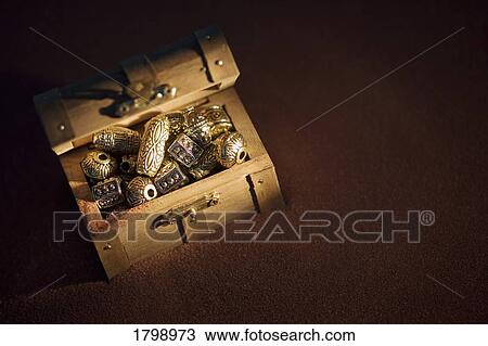 Stock Image - Golden beads in a box. Fotosearch