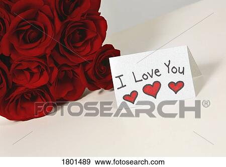 Stock Photo - I love you card beside roses. Fotosearch