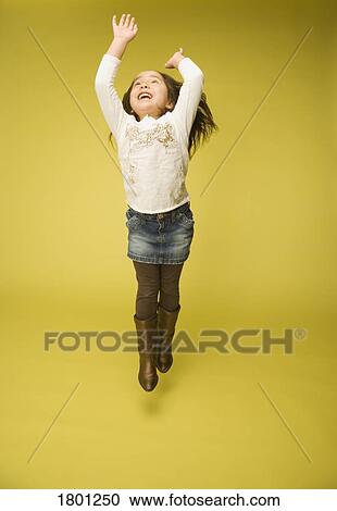 Stock Image - Little girl jumping in the air. Fotosearch