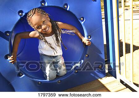 Stock Photo - Little girl playing on park equipment. Fotosearch