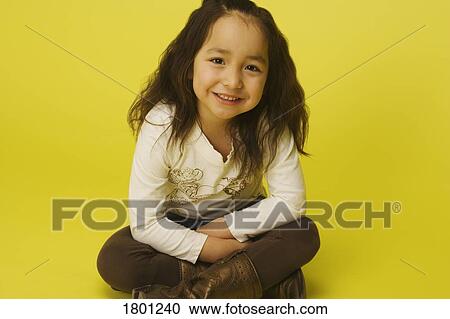Stock Image - Little girl sitting cross legged. Fotosearch