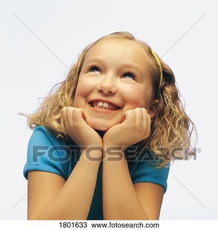 Little girl with chin resting in hands, smiling and looking upwards View Large Photo Image Stock Image - Little girl with chin resting in hands, smiling and looking upwards. Fotosearch
