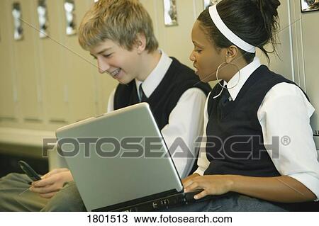 Stock Image - Male and Female private school students with laptop. Fotosearch