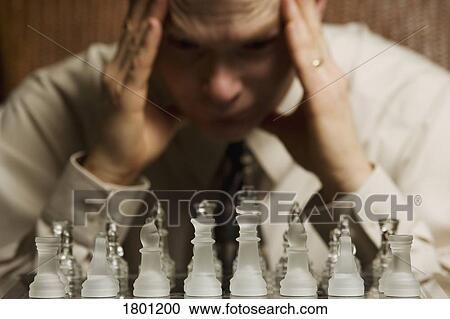 Stock Image - Man concentrating on a chess game. Fotosearch