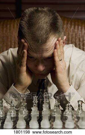 Stock Photo - Man concentrating on chess game. Fotosearch