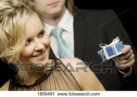 Man offering a gift to woman View Large Photo Image Stock Image - Man offering a gift to woman. Fotosearch