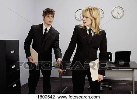 Stock Image - Man Passing Baton To Woman In Office. Fotosearch