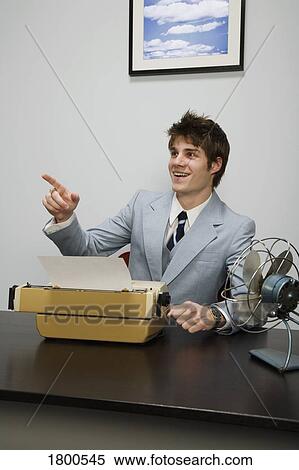 Stock Photography - Man Pointing In Front Of Typewriter. Fotosearch