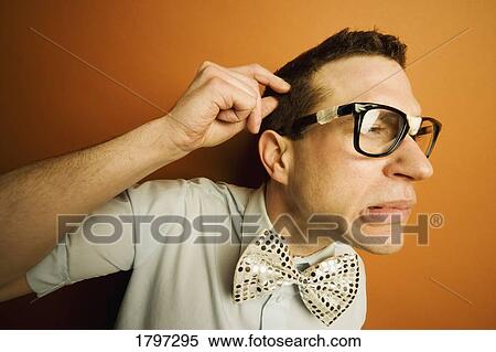 Stock Photography - Man wearing taped glasses and a bow tie. Fotosearch