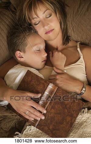 Mother and son asleep after reading on a bed with book over them View Large Photo Image Stock Photo - Mother and son asleep after reading on a bed with book over them. Fotosearch