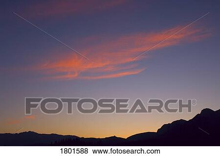 Stock Photo - Mountain silhouette sunset with orange clouds . Fotosearch