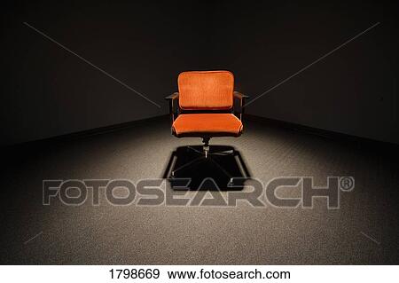 Stock Photo - Office chair under a spotlight. Fotosearch