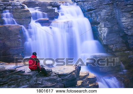 Person sitting near Athabasca Falls View Large Photo Image Stock Photo - Person sitting near Athabasca Falls. Fotosearch