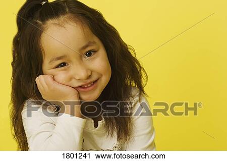 Stock Image - Portrait of a little girl with a yellow background. Fotosearch