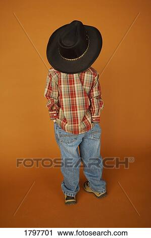 Stock Image - Rear view of a boy wearing western clothing. Fotosearch