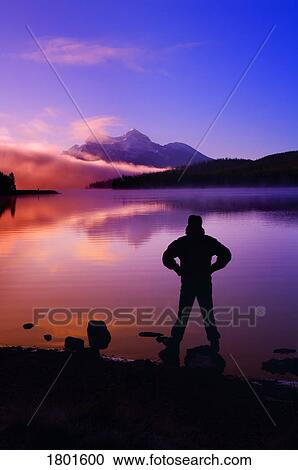 Silhouette of a man at a mountain lake View Large Photo Image Stock Image - Silhouette of a man at a mountain lake . Fotosearch