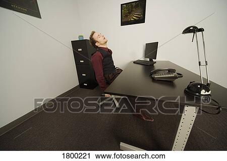 Stock Image - Sleeping at work. Fotosearch
