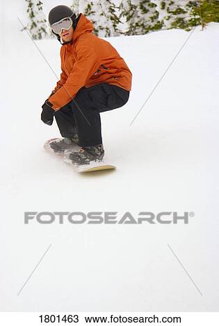 Snowboarder going down snowy hill View Large Photo Image Stock Image - Snowboarder going down snowy hill. Fotosearch
