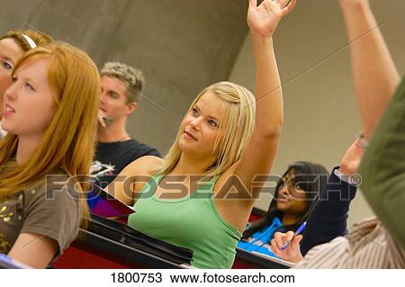 Stock Image - Students raising their hands in class. Fotosearch