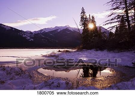 Stock Photography - Sun setting in the mountains. Fotosearch