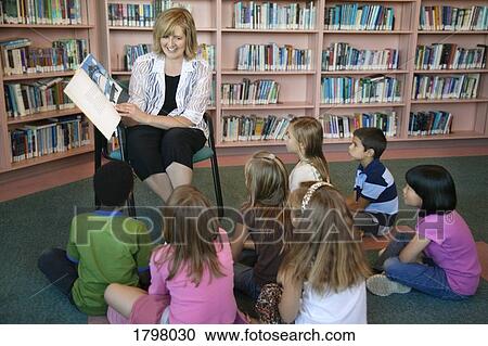 Stock Image - Teacher and students in a library. Fotosearch