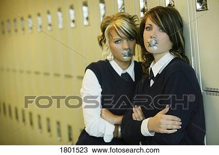 Two female students standing in school hallway with "x" taped over mouths View Large Photo Image Stock Image - Two female students standing in school hallway with "x" taped over mouths. Fotosearch