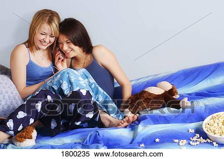 Stock Photography - Two girls sitting in pajamas. Fotosearch