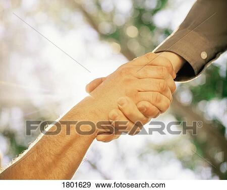Stock Photo - Two hands in a grasp as if one is helping the other up. Fotosearch