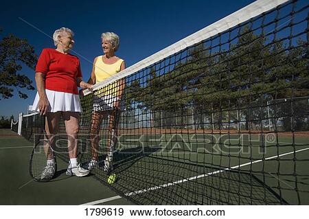 Stock Photo - Two women at the tennis court. Fotosearch