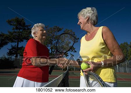 Two women shaking hands on tennis court View Large Photo Image Stock Image - Two women shaking hands on tennis court. Fotosearch