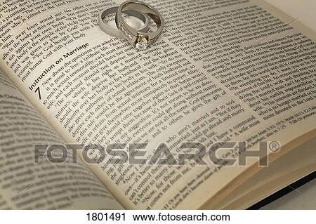 Stock Image - Wedding rings on an open Bible. Fotosearch