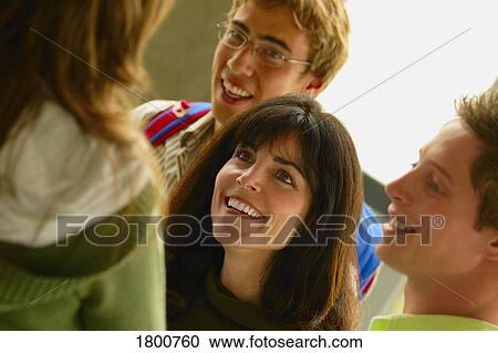 Stock Image - Woman conversing with young adults. Fotosearch