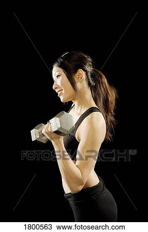 Stock Image - Woman exercising with barbell. Fotosearch