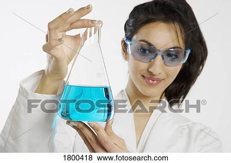 Woman holding a beaker View Large Photo Image Stock Photo - Woman holding a beaker. Fotosearch