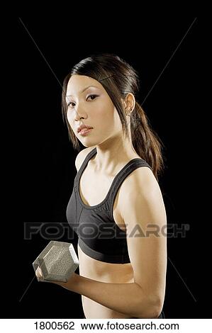 Stock Image - Woman holding barbell. Fotosearch