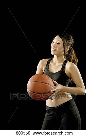 Stock Photo - Woman holding basketball. Fotosearch