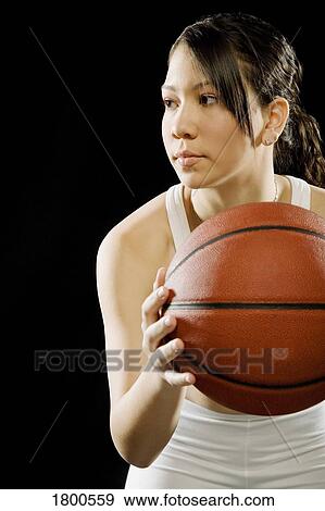Stock Photo - Woman holding basketball. Fotosearch
