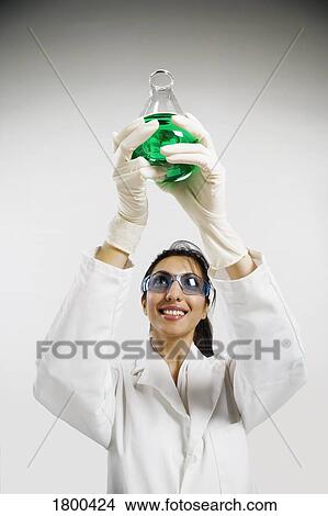 Picture - Woman holding beaker. Fotosearch