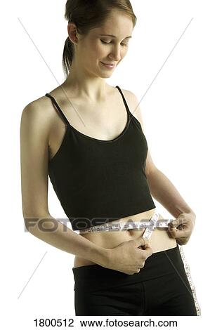Stock Image - Woman measuring waist. Fotosearch