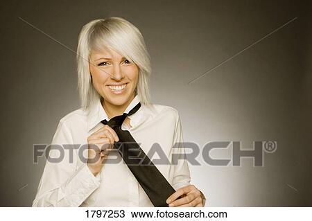 Stock Image - Woman pulling at her neck-tie. Fotosearch