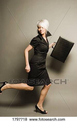 Stock Photo - Woman running while holding a briefcase. Fotosearch