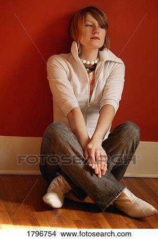 Woman sitting against a wall View Large Photo Image Picture - Woman sitting against a wall. Fotosearch