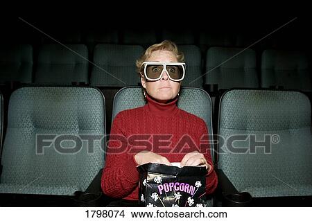 Woman sitting in a movie theater View Large Photo Image Picture - Woman sitting in a movie theater. Fotosearch