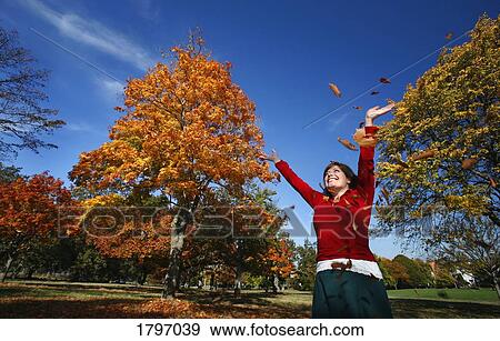 Woman throwing leaves in the air View Large Photo Image Stock Photo - Woman throwing leaves in the air. Fotosearch