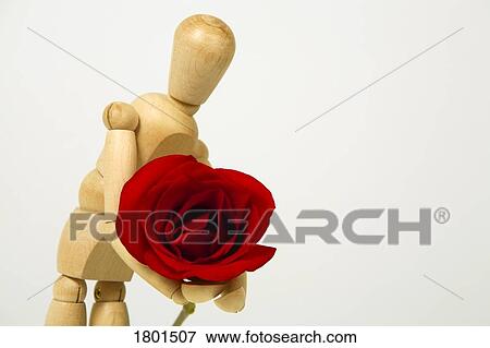 Stock Photo - Wooden doll holding red rose. Fotosearch
