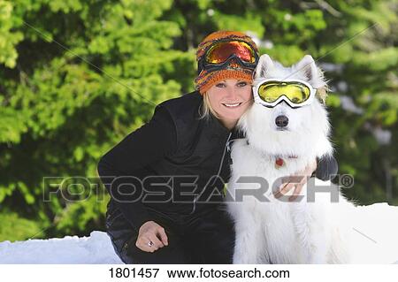 Young adult sitting in snow with dog, both with ski goggles View Large Photo Image Stock Photo - Young adult sitting in snow with dog, both with ski goggles. Fotosearch