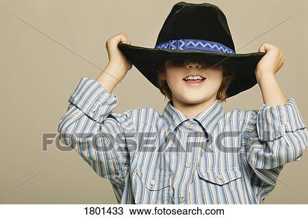 Stock Image - Young boy wearing cowboy hat. Fotosearch
