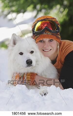 Young girl laying with dog in the snow View Large Photo Image Stock Photograph - Young girl laying with dog in the snow. Fotosearch