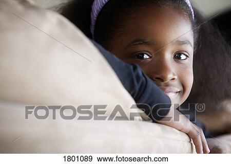 Stock Photo - Young girl smiling and head resting on arms. Fotosearch